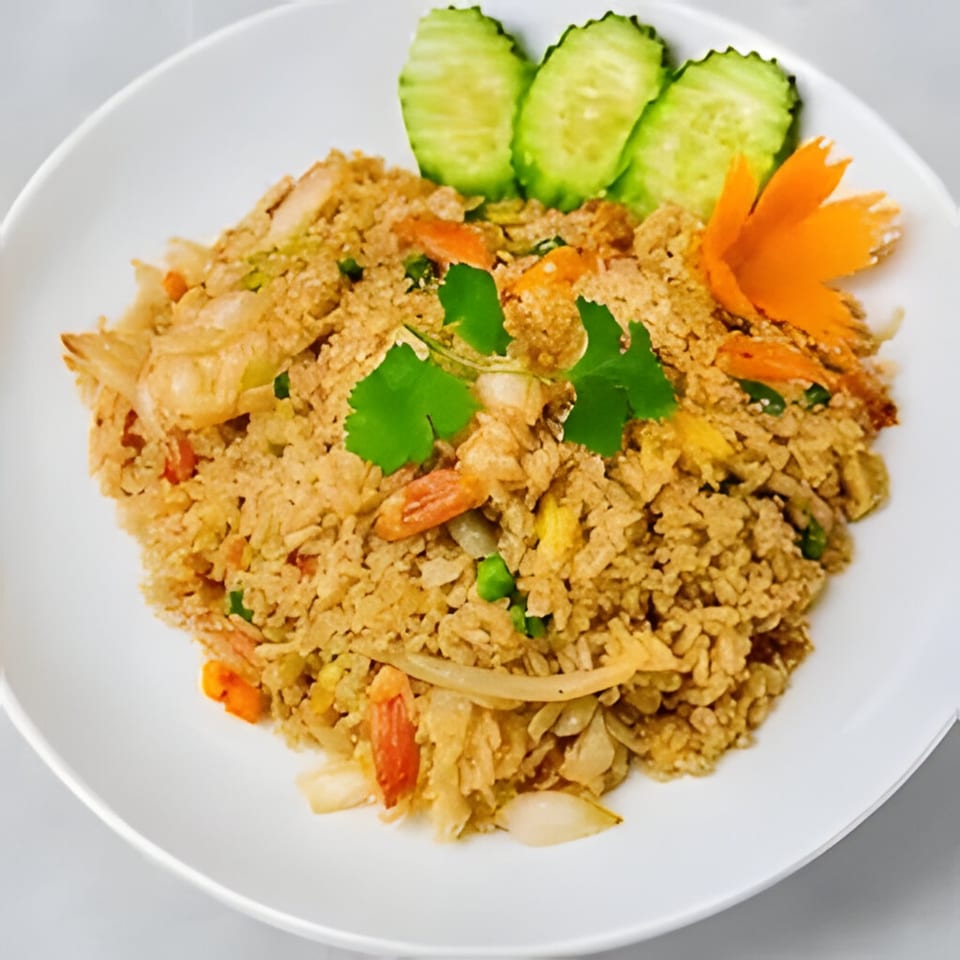 Angry Thai's crab fried rice, garnished with cucumber slices, cilantro, and a carrot flower.