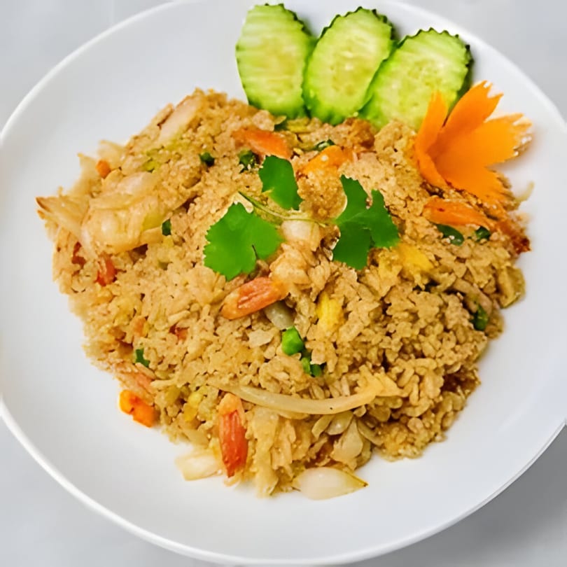 Angry Thai's crab fried rice, garnished with cucumber slices, cilantro, and a carrot flower.